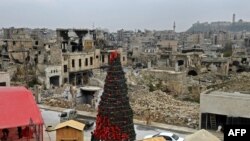 Workers set up a Christmas tree at al-Hatab square, one of the oldest in Syria's northern city of Aleppo, Dec. 12, 2022. 