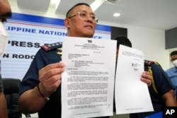 Kepala Polisi Filipina, Jenderal Polisi Rodolfo Azurin Jr., memegang surat pengunduran dirinya dalam konferensi pers di markas polisi Camp Crame, Kamis, 5 Januari 2023, di Metro Manila, Filipina.(AP/Aaron Favila)