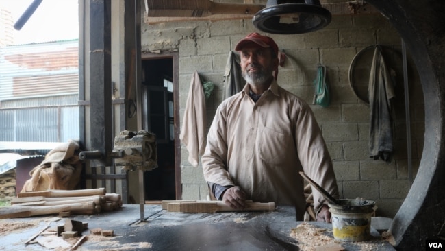 Mohammad Shafi Dar has been working with Model Sports Industries, a cricket bat manufacturing factory, for two decades. (Wasim Nabi/VOA)