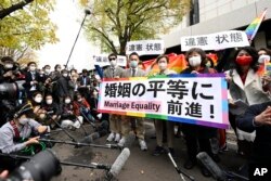 Para penggugat dan pendukung memegang spanduk bertuliskan "Kemajuan menuju kesetaraan pernikahan" di luar pengadilan distrik Tokyo di Tokyo, Jepang, Rabu, 30 November 2022. (Foto: Kyodo News via AP)