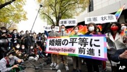 Plaintiffs and supporters hold a banner saying "Advancement to marriage equality" outside the Tokyo district court in Tokyo, Nov. 30, 2022. Japan's lack of law to protect the right of same-sex couples to marry and become families was ruled unconstitutional by the Tokyo District Court on Nov. 30, 2022.