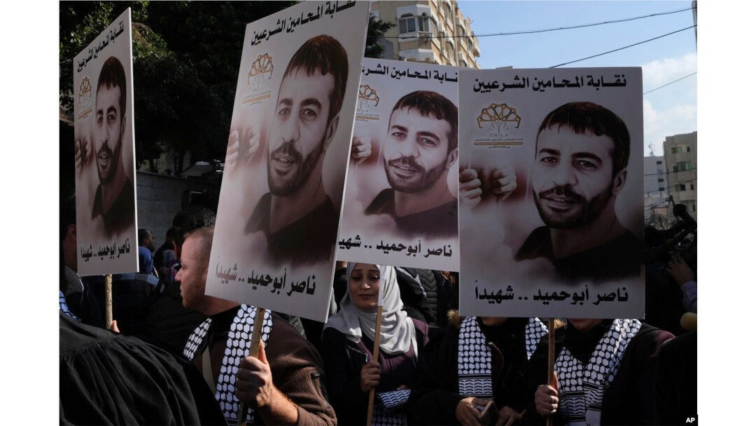 FILE - Aksi protes warga Palestina dengan memegang poster tahanan Palestina Nasser Abu Hamid di depan kantor Komite Internasional Palang Merah di Kota Gaza, Selasa, 20 Desember 2022. (AP/Adel Hana, File)