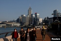 People wearing face masks walk on the street in Hong Kong, China, Dec. 28, 2022.