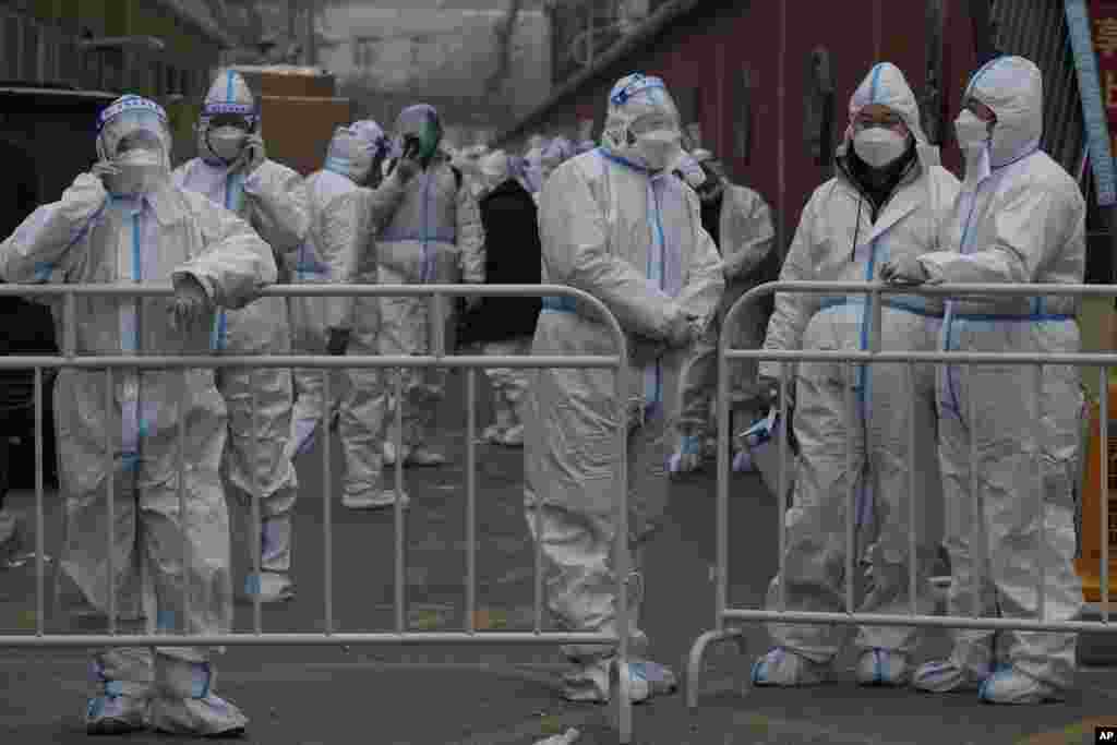 Workers in protective suits prepare their duties in a locked down neighborhood as part of COVID-19 controls in Beijing, China.