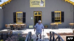 Frans Hugo delivers copies of his newspaper at a restaurant in Loxton, South Africa, Nov. 24, 2022.