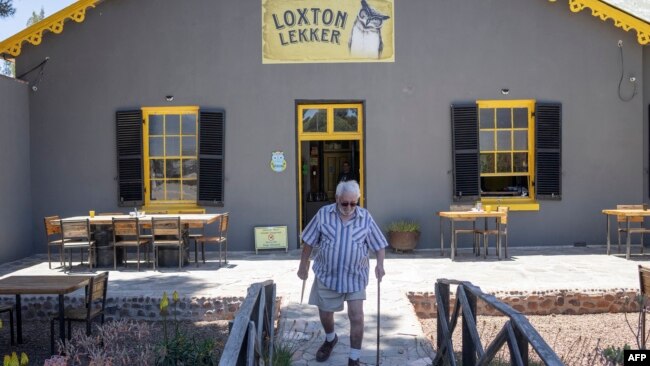 Frans Hugo delivers copies of his newspaper at a restaurant in Loxton, South Africa, Nov. 24, 2022.
