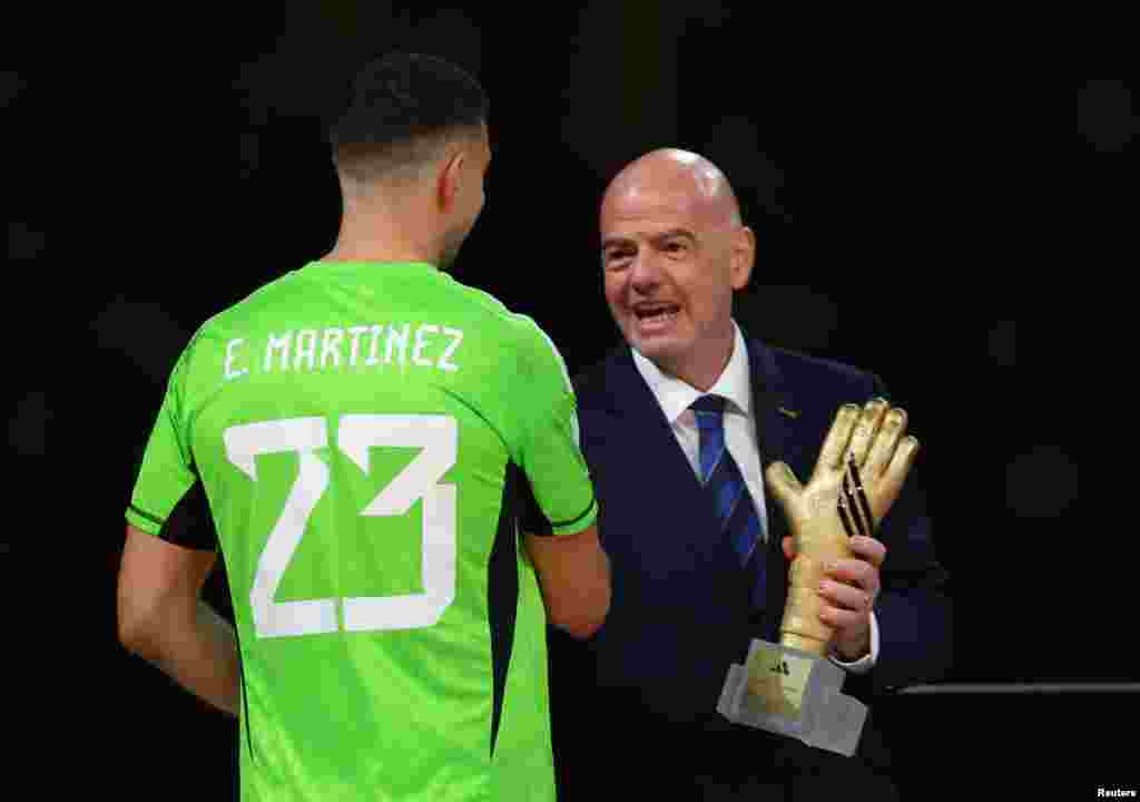 O presidente da FIFA, Gianni Infantino, entrega o troféu Luva de Ouro ao guarda-redes argentino Emiliano &quot;Dibu&quot; Martínez.