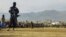 FILE - A Taliban security personnel stands guard as people attend to watch publicly flogging of women and men at a football stadium in Charikar city of Parwan province on Dec. 8, 2022.