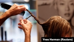 Belgian hairdresser at salon L'Atelier Chedly Boussigua cuts a customer's hair, in Brussels, Belgium November 4, 2022. (REUTERS/Yves Herman)