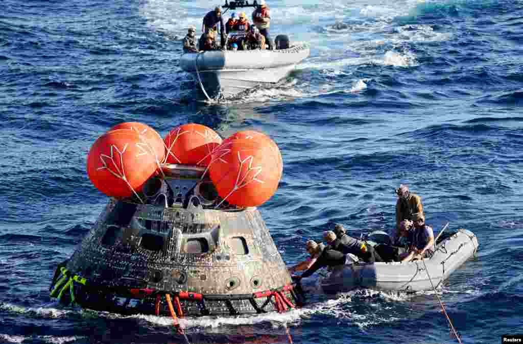 U.S. Navy divers secure NASA&#39;s Orion Capsule after it splashed down, Dec. 11, 2022, following a successful uncrewed Artemis I moon mission, seen from aboard the U.S.S. Portland in the Pacific Ocean off the coast of Baja California, Mexico.
