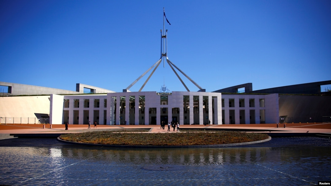 FILE - Tourists walk around the forecourt of Australia's Parliament House in Canberra, Australia, Oct. 16, 2017. 