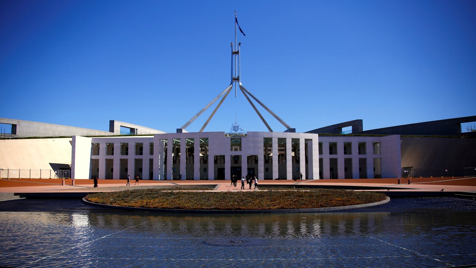 FILE - Tourists walk around the forecourt of Australia's Parliament House in Canberra, Australia, Oct. 16, 2017. 