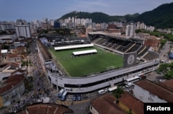 Mourners line up to pay their respects to Brazilian soccer legend Pele as he lies in state on the pitch of his former club Santos' Vila Belmiro Stadium, Santos, Jan. 2, 2023.