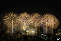 Fireworks explode over the Chao Phraya River during New Year celebrations in Bangkok on January 1, 2023. (Sakchai Lalit/AP)