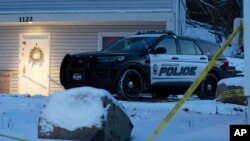 FILE - A Moscow, Idaho, police officer stands guard in his vehicle, Nov. 29, 2022, at the home where four University of Idaho students were found dead on Nov. 13, 2022. Police arrested a suspect on Dec. 30, 3022.