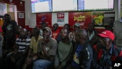 Customers watch screens in a sports betting shop in the low-income Kibera neighborhood of the capital Nairobi, Kenya. (AP Photo/Brian Inganga)