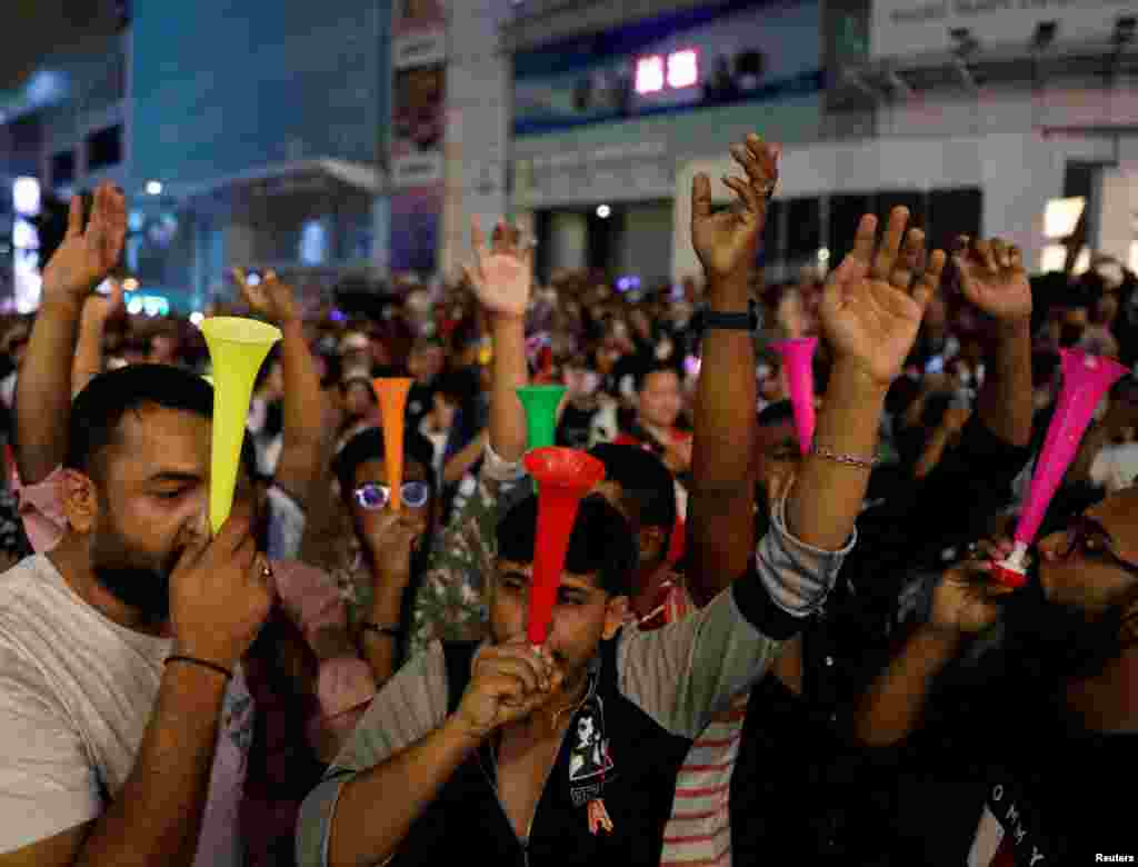 Revelers blow horn as they celebrates New Year's Eve in Kuala Lumpur, Malaysia, Dec. 31, 2022. 