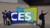 FILE - People take pictures in front of a sign during the CES tech show on Jan. 6, 2022, in Las Vegas.