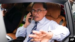 Opposition leader Anwar Ibrahim, talks on a phone as he leaves his office in Kuala Lumpur, Malaysia, Nov. 22, 2022.