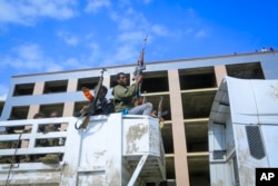 FILE - Armed Tigray forces ride through the streets in open-top trucks, in Mekele, the capital of the Tigray region of northern Ethiopia, Oct. 22, 2021.