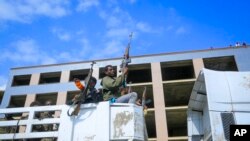 FILE - Armed Tigray forces ride through the streets in open-top trucks, in Mekele, the capital of the Tigray region of northern Ethiopia, Oct. 22, 2021. A new report says detained Tigrayan soldiers were massacred at a camp in southern Ethiopia in November