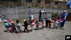 Children play during recess at a government-run daycare where they are fed one meal at lunch time in Catzuqui de Velasco, a rural area without reliable basic services like water and sewage, on the outskirts of Quito, Ecuador, Dec. 1, 2022. 