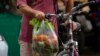 A shopper leaves a market on a bike in Havana, Dec. 23, 2022. 