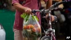 A shopper leaves a market on a bike in Havana, Dec. 23, 2022. 