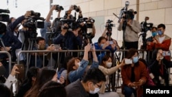 FILE - Members of the media work at the West Kowloon Magistrates' courts in Hong Kong, China, Nov. 25, 2022.