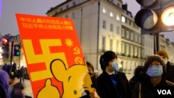 示威者拿着抗議標語牌在中國駐英大使館外示威。(美國之音/鄭樂捷）
