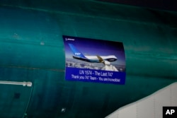 A poster on the side of the final Boeing 747 built notes the aircraft's historical status and says "Thank you 747 Team." The plane rolled out of a hangar in Everett, Washington, on Dec. 6, 2022.