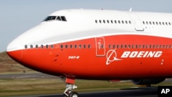 FILE - A Boeing 747-8 passenger plane taxis for its first flight, March 20, 2011, down Paine Field in Everett, Washington. Boeing completed building its last 747 this year, introducing it to the public on Dec. 6, 2022.