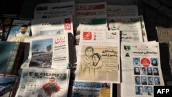 Sebuah lapak koran di Teheran tampak menjajakan surat kabar Hammihan, yang mengabarkan soal penangkapan terhadap jurnalis yang mengungkap soal kasus kematian Mahsa Amini, pada 30 Oktober 2022. (AFP/Atta Kenare)