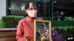 A well-wisher sits with a photo of Princess Bajrakitiyabha Mahidol at Chulalongkorn Hospital in Bangkok on Dec. 16, 2022.