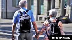 FILE - A couple walks while holding hands in this undated stock photo. A child born in the U.S. in 2021 is expected to live 76.4 years, the lowest figure since 1996, according to data from the U.S. Centers for Disease Control and Prevention.