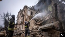 Os bombeiros do Serviço de Emergência do Estado Ucraniano trabalham para extinguir um incêndio no edifício que foi destruído por um ataque russo em Kryvyi Rih, Ucrânia, 16 de Dezembro de 2022. 