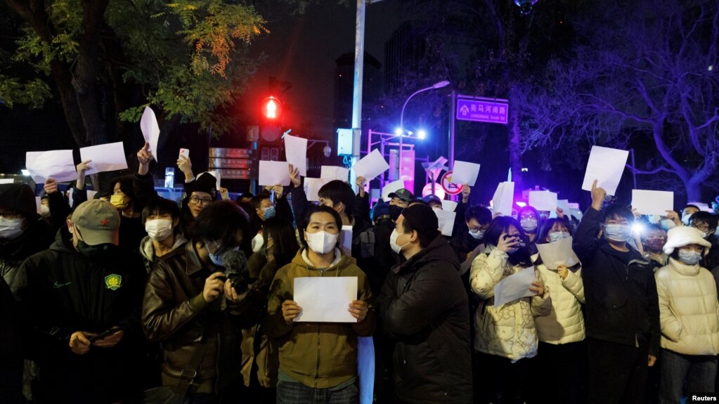2022年11月28日，在中国北京，随着新冠肺炎疫情的持续，人们在为乌鲁木齐火灾遇难者守夜后，手持白纸抗议新冠肺炎疫情限制措施。(photo:VOA)