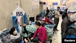 Patients lie on beds in a hallway in the emergency department of Zhongshan Hospital amid the COVID-19 outbreak in Shanghai, Jan. 3, 2023. 