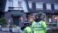 Police officers stand on duty at the Lighthouse Inn in Wallasey Village, near Liverpool, England, Sunday, Dec. 25, 2022. A Christmas Eve shooting at a pub in northwest England killed a young woman and wounded three men, police said Sunday. 