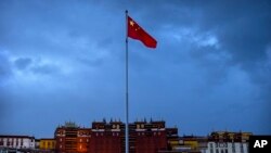 FILE - The Chinese flag flies in western China's Tibet Autonomous Region, on June 1, 2021. China has sanctioned two U.S. individuals in retaliation for action taken by Washington over human rights abuses in Tibet, the government said Dec. 23, 2022.