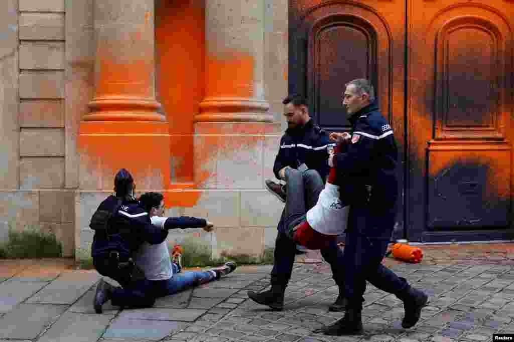 French gendarmes arrest environmental activists with the Last Renovation group after they sprayed paint on the Hotel Matignon to draw attention to climate change and to denounce what they say is the failure of the French state to honor its climate commitments, in Paris.