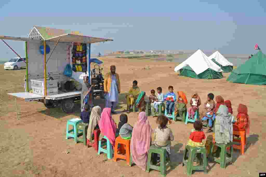 Internally displaced flood-affected children attend a mobile class near makeshift camp in the flood-hit area of Dera Allah Yar in Jaffarabad district of Balochistan province, Pakistan.