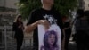 FILE - Protesters hold posters for slain Palestinian-American journalist Shireen Abu Akleh near the Augusta Victoria Hospital in east Jerusalem ahead of a visit by U.S. President Joe Biden, July 15, 2022.