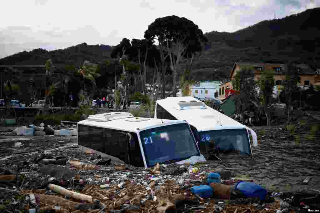 Damaged buses lie amongst debris following a landslide on the Italian holiday island of Ischia, Italy.