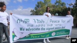 FILE - Girls hold a banner in support of the recent peace deal agreed between the Ethiopian federal government and Tigray forces, at an event in Mekele, the capital of Ethiopia's Tigray region, Nov. 26, 2022. African officials will be monitoring the deal's implementation.