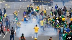 Protesters, supporters of former President Jair Bolsonaro, clash with police during a protest outside the Planalto Palace building in Brasilia, Brazil, Jan. 8, 2023. 