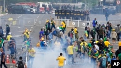 Para pengunjuk rasa, pendukung mantan Presiden Jair Bolsonaro, bentrok dengan polisi saat protes di luar gedung Istana Planalto di Brasilia, Brazil, 8 Januari 2023. (Foto: AP)