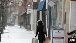 Wateja wakaidi hali mbaya ya hewa kutokana na dharuba ya theluji mjini Birmingham, Michigan.