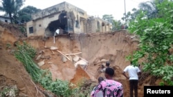 Sejumlah warga tampak memeriksa kerusakan yang ditimpulkan oleh hujan deras yang menyebabkan banjir dan tanah longsor di pinggiran Kota Kinshasa, Kongo, pada 13 Desember 2022. (Foto: Reuters/Stringer)