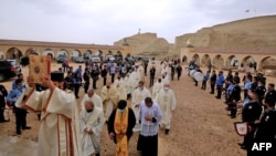 FILE - Priests celebrate a mass at the site where Jesus is believed by Christians to have been baptized by John the Baptist, in the Jordan River valley, some 50kms (30 miles) southwest of the Jordanian capital Amman, Jan. 14, 2022. 